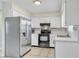 Well-lit kitchen featuring stainless steel appliances, white cabinets, and tile flooring at 2705 20Th Avenue W Dr, Bradenton, FL 34205