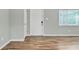 Living area with hard wood floors, a white door, a window with blinds, and light grey walls at 2705 20Th Avenue W Dr, Bradenton, FL 34205