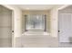 Relaxing bathroom featuring a soaking tub and a glass block window for natural light at 3201 Wilderness W Blvd, Parrish, FL 34219