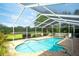 Private screened pool surrounded by a brick paver deck and lush landscaping at 3201 Wilderness W Blvd, Parrish, FL 34219
