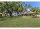 Spacious backyard with a large tree, screened porch, and well-maintained lawn at 3209 2Nd W Ave, Bradenton, FL 34205