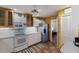 Traditional kitchen featuring white cabinets, stainless steel refrigerator, white appliances, and terra cotta tile flooring at 3209 2Nd W Ave, Bradenton, FL 34205