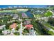 Beautiful aerial shot of waterfront community with golf course, tropical foliage, and stunning home at 3302 Sabal Cove Ln, Longboat Key, FL 34228