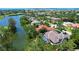 Scenic aerial view of a luxury home with a screened pool, waterfront access, and lush tropical surroundings at 3302 Sabal Cove Ln, Longboat Key, FL 34228