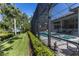 Expansive backyard showcasing a screened-in pool, lush landscaping, and tranquil waterfront views at 3302 Sabal Cove Ln, Longboat Key, FL 34228