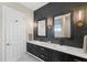 Bathroom with a double vanity, black cabinetry, modern fixtures and decorative wall sconces at 3302 Sabal Cove Ln, Longboat Key, FL 34228
