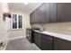 Functional laundry room equipped with modern washer, dryer, sink, and ample storage cabinetry at 3302 Sabal Cove Ln, Longboat Key, FL 34228
