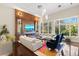 Bright living room with a fireplace, bar and a wall of windows bringing in tons of natural light at 3302 Sabal Cove Ln, Longboat Key, FL 34228