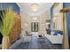Elegant living room with crystal chandeliers, blue accent wall, and stone floors at 3302 Sabal Cove Ln, Longboat Key, FL 34228