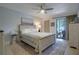 Bedroom featuring neutral walls, stylish furnishings, ceiling fan, and sliding door to covered and screened lanai at 3500 El Conquistador Pkwy # 301, Bradenton, FL 34210
