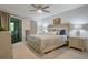 Relaxing bedroom featuring neutral walls, stylish furnishings, sliding door to balcony, and ceiling fan at 3500 El Conquistador Pkwy # 301, Bradenton, FL 34210