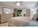 Bright bedroom featuring neutral walls, stylish furnishings, sliding door to balcony, ceiling fan and spacious closet at 3500 El Conquistador Pkwy # 301, Bradenton, FL 34210