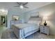 Inviting bedroom featuring neutral walls, stylish furnishings, ceiling fan and view to main hallway at 3500 El Conquistador Pkwy # 301, Bradenton, FL 34210