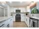 Bright, updated kitchen featuring modern appliances, white cabinetry, and wooden floors at 3500 El Conquistador Pkwy # 301, Bradenton, FL 34210