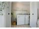 Functional laundry room features a washer and dryer, shelving, and bright lighting at 3500 El Conquistador Pkwy # 301, Bradenton, FL 34210
