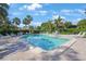 Bright outdoor pool area features lounge seating and many palms on a sunny day at 3500 El Conquistador Pkwy # 301, Bradenton, FL 34210