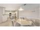 Open-concept dining area with a modern light fixture, seamlessly connected to the kitchen with bar seating at 3608 Avenida Madera, Bradenton, FL 34210