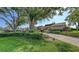 This property features a lush green lawn, mature trees, and meticulously manicured shrubs, enhancing its curb appeal at 3608 Avenida Madera, Bradenton, FL 34210