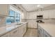 Bright, modern kitchen features an island with seating, white cabinets, stainless appliances, and a view of the pool at 3608 Avenida Madera, Bradenton, FL 34210