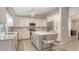 Bright kitchen boasts white cabinetry, stainless steel appliances, island with seating, and wood-look floors at 3608 Avenida Madera, Bradenton, FL 34210
