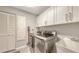 Bright laundry room with white cabinets, a utility sink, and front load washer and dryer at 3608 Avenida Madera, Bradenton, FL 34210