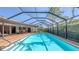 Inviting pool surrounded by a screened enclosure and brick patio with outdoor dining space at 3608 Avenida Madera, Bradenton, FL 34210