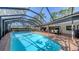A clear, refreshing pool is enclosed by a screen with an outside dining area beyond at 3608 Avenida Madera, Bradenton, FL 34210