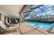 Enclosed pool area featuring lounge chairs and covered patio seating, perfect for relaxation at 3608 Avenida Madera, Bradenton, FL 34210
