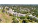 Wide aerial shot showcasing the condo buildings, golf course, and pond in a well-maintained community at 3750 Pinebrook Cir # 104, Bradenton, FL 34209