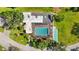 Top-down aerial of a screened pool, shuffleboard court, and well-maintained landscaping at 3750 Pinebrook Cir # 104, Bradenton, FL 34209