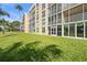 Exterior view of the condo building from the lawn, featuring screened lanais and multiple windows at 3750 Pinebrook Cir # 104, Bradenton, FL 34209