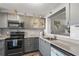 Well-lit kitchen features gray cabinets, quartz countertops, and stainless steel appliances at 3750 Pinebrook Cir # 104, Bradenton, FL 34209