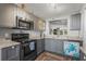 Updated kitchen featuring gray cabinets, stainless steel appliances, and a pass-through window at 3750 Pinebrook Cir # 104, Bradenton, FL 34209