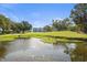 Scenic view of lush green lawn and tranquil pond with building in background under a blue sky at 3750 Pinebrook Cir # 104, Bradenton, FL 34209