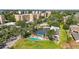 Aerial view highlighting the screened pool, shuffleboard court, and lush landscaping at 3750 Pinebrook Cir # 104, Bradenton, FL 34209