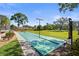 A view of the shuffleboard court with well-maintained landscaping and a lush lawn at 3750 Pinebrook Cir # 104, Bradenton, FL 34209