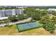 Aerial view of well-maintained tennis courts surrounded by lush landscaping and mature trees at 3750 Pinebrook Cir # 104, Bradenton, FL 34209