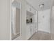 Inviting hallway featuring custom built-ins, stylish mirror, and neutral color palette at 3806 Gulf Of Mexico Dr # C311, Longboat Key, FL 34228