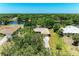 An aerial view of a lakefront home with mature trees and a long driveway at 410 136Th E Ct, Bradenton, FL 34212