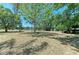 A beautiful open backyard with mature trees and a view of the lake beyond at 410 136Th E Ct, Bradenton, FL 34212