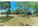 A view of the backyard with mature trees and partial views of the lake at 410 136Th E Ct, Bradenton, FL 34212