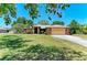 Charming single-story home featuring a well-manicured lawn, mature trees, and an attached two-car garage at 410 136Th E Ct, Bradenton, FL 34212