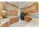 Well-lit kitchen with ample oak cabinets, modern black refrigerator, and spacious layout for cooking at 410 136Th E Ct, Bradenton, FL 34212