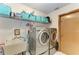 Functional laundry room with silver washer and dryer and plenty of storage space on shelves at 410 136Th E Ct, Bradenton, FL 34212