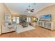 Open-concept living room with hardwood floors, a stone fireplace, and a view into the dining area at 410 136Th E Ct, Bradenton, FL 34212