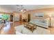 Open living room with hardwood floors offering a view of the dining area and front entryway at 410 136Th E Ct, Bradenton, FL 34212