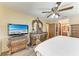 The main bedroom features a ceiling fan, TV, and decorative wood dresser at 410 136Th E Ct, Bradenton, FL 34212