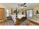 Serene main bedroom with a king canopy bed, ceiling fan, and access to a private lanai at 410 136Th E Ct, Bradenton, FL 34212