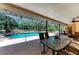 Relaxing covered patio features comfortable seating and views of the gorgeous in-ground pool and lush backyard at 410 136Th E Ct, Bradenton, FL 34212