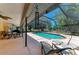 Inviting covered patio with seating, fan, and view of the gorgeous in-ground pool and surrounding landscape at 410 136Th E Ct, Bradenton, FL 34212